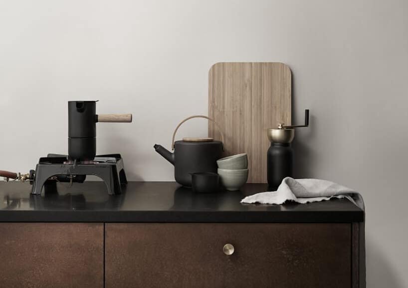 elegancka ciemna kawiarka Collar od Stelton na czarnym blacie szafki kuchennej z ciemno brązowymi frontami