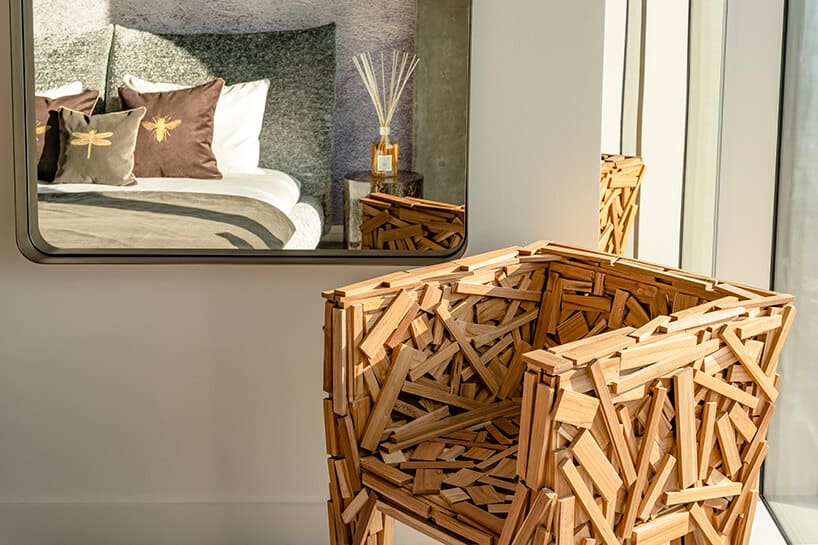 wyjątkowy fotel z drewnianych deseczek na tle dużego lustra w apartamencie Nature na Złotej 44