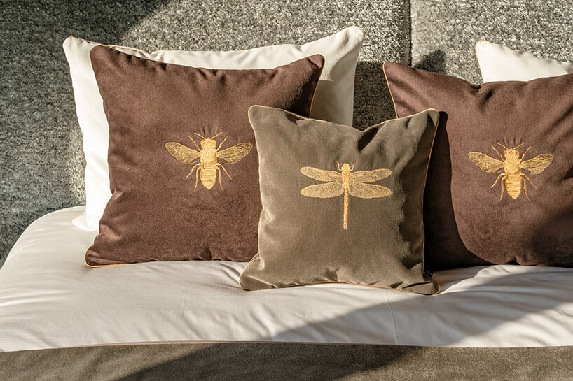 wyjątkowe ciemne poszewki ze złotymi wyszytymi owadami na łóżku w apartamencie Nature na Złotej 44