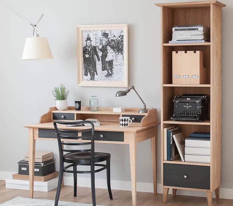 retro biurko w jasnym kolorze drewna oraz czarnymi szufladami oraz krzesłem