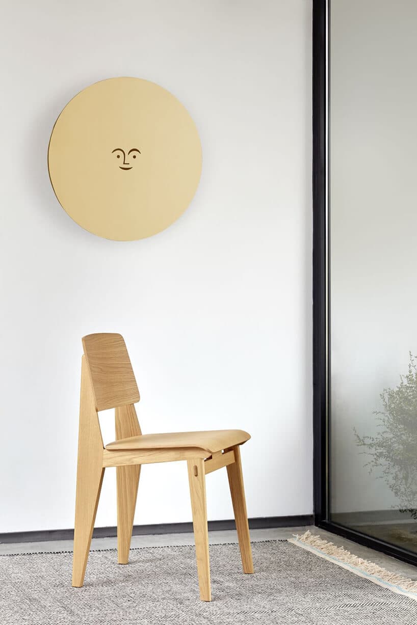 drewniane krzesło przy białej ścianie z okrągłym panelem z drewna
