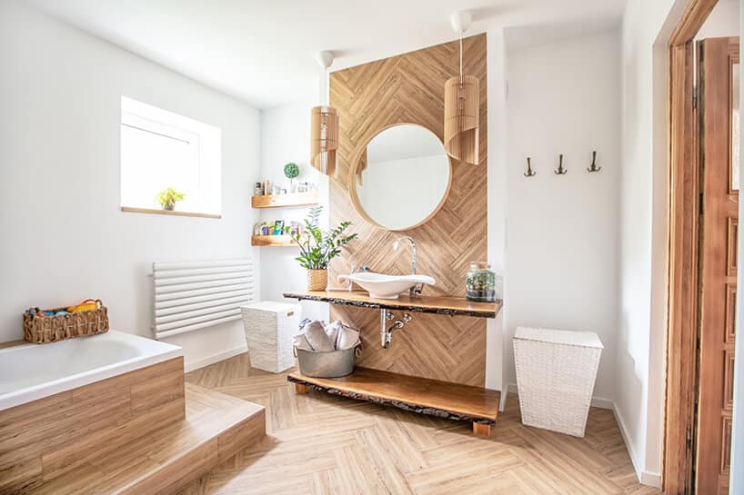 elegancka białą łazienka od Koło z drewnianą zabudową lustra z umywalką oraz wanną