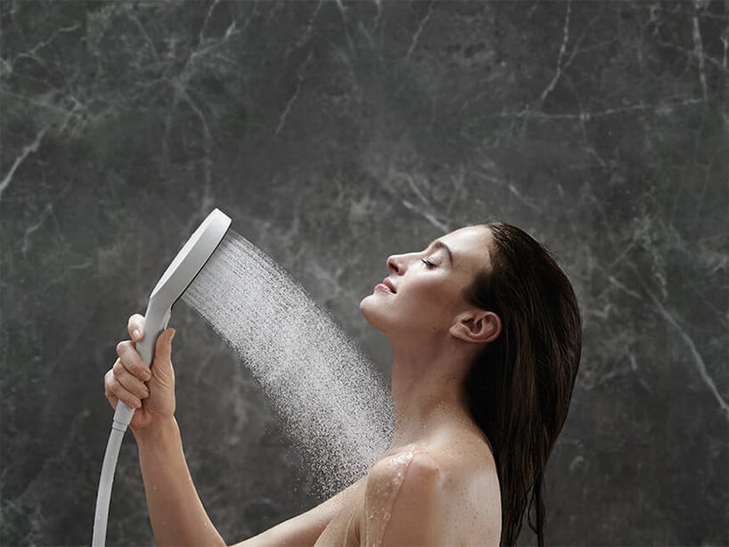 ekskluzywny zestaw prysznicowy Hansgrohe linia Rainfinity używany przez kobietę w szarej kamiennej łazience