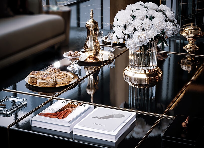 luksusowe wnętrze apartamentu w Dubaju od Covet House czarny stół ze złotymi akcentami ze złotymi naczyniami