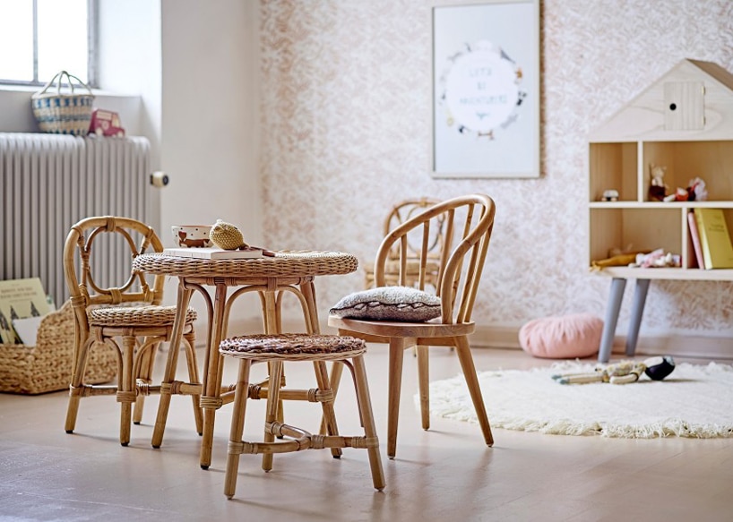 zestaw małych drewnianych mebli dla dziecka krzesła z oparciem ze stołkiem na tle wytapetowanej ściany