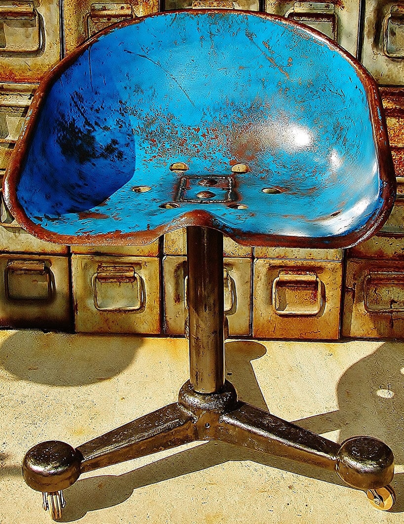 niebieskie siedzisko na kółkach ze starej maszyny rolniczej