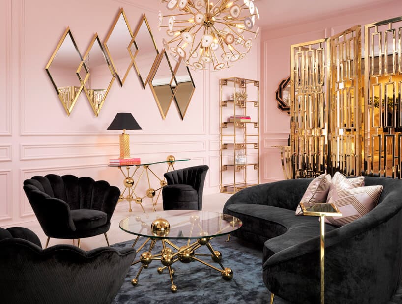 różowe wnętrze ze złotymi akcentami i czarną sofą