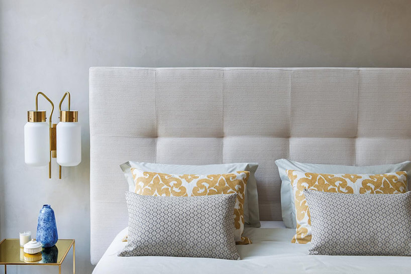 białe poduszki ze złotymi wzorami na łóżku