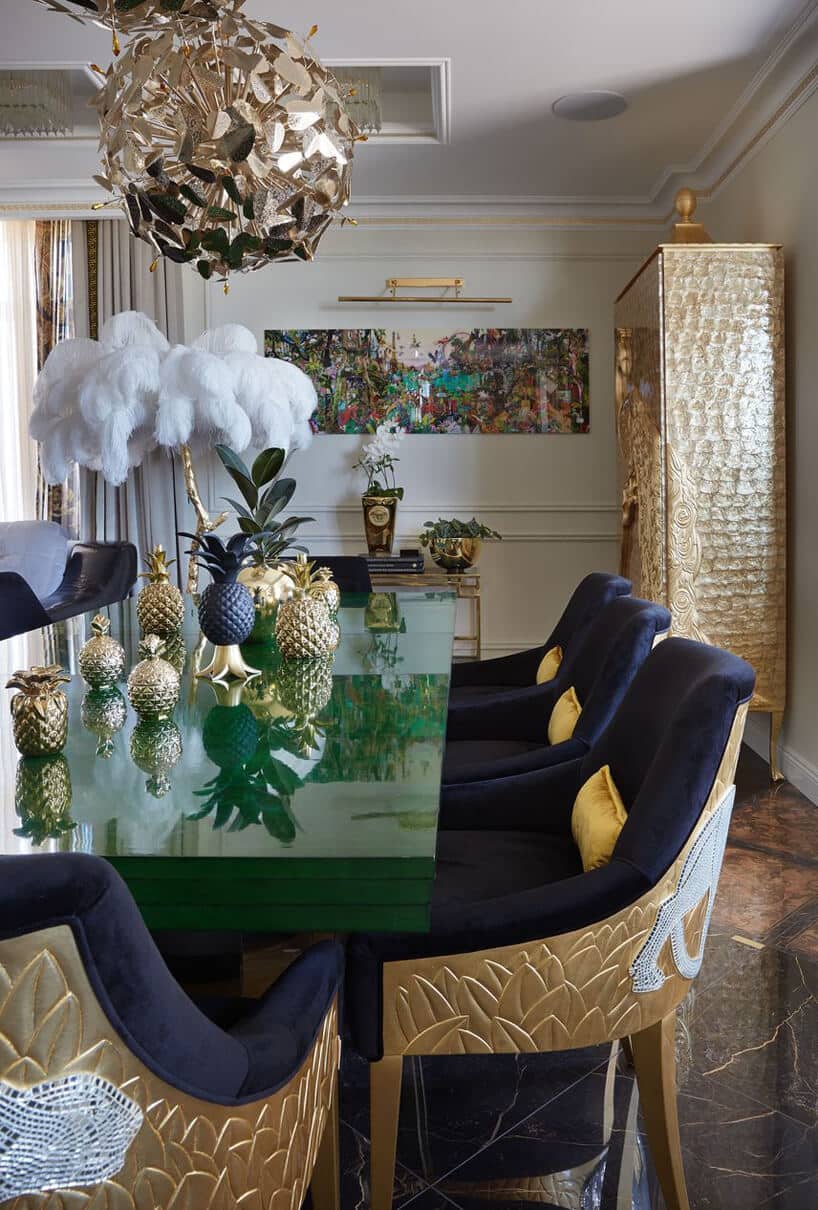 zielony stół w jadalni z granatowymi krzesłąmi ze złotymi wykończeniami
