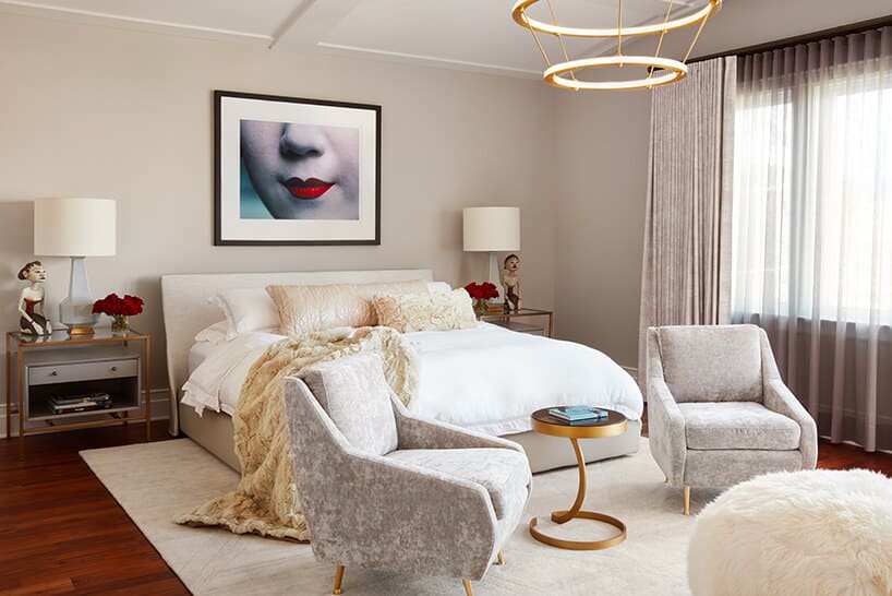 modernistyczne wnętrze Ravenswood Residence elegancka sypialnia z dwoma szarymi fotelami złotymi małym stolikiem ustawionymi przed dużym beżowym łóżkiem