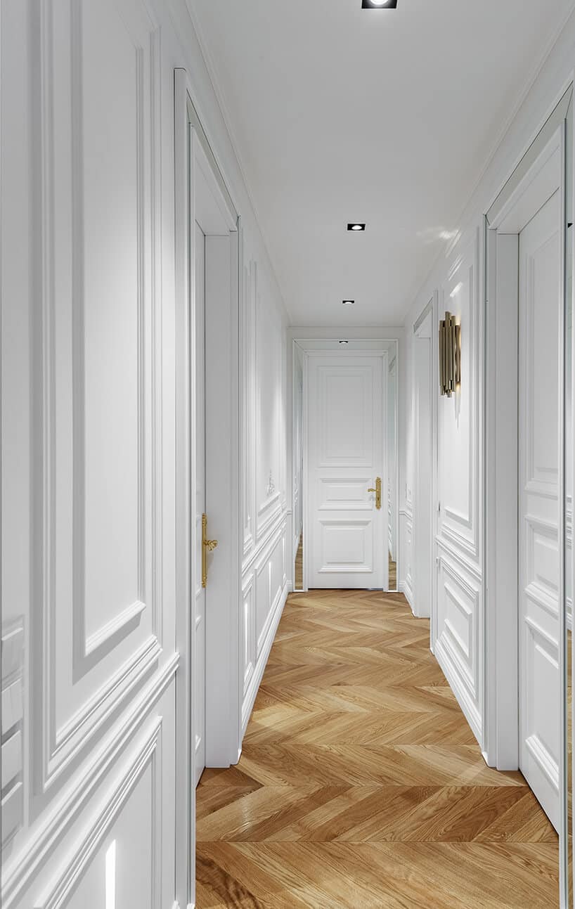 biały przedpokój z drewnianym parkietem z drzwiami ze złotymi klamkami