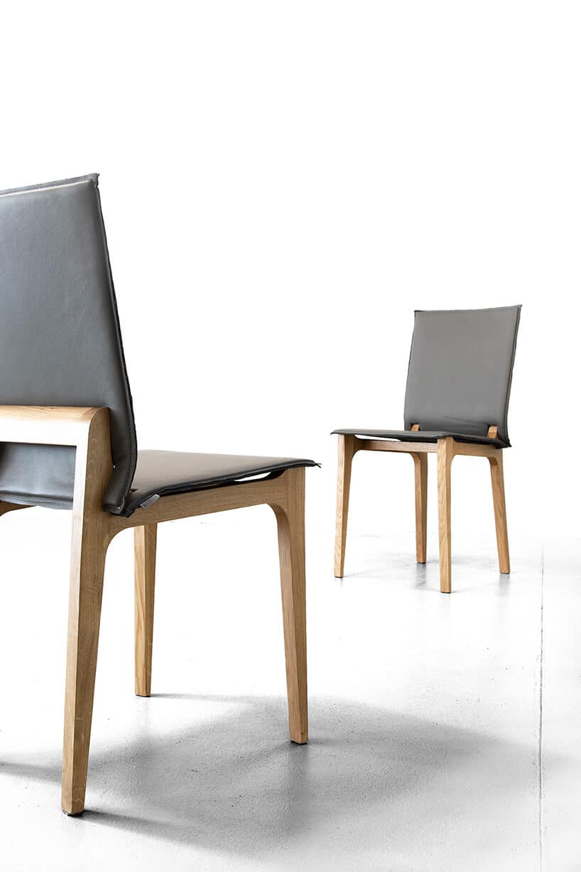 dwa nowoczesne drewniane krzesła z szarym skórzanym siedziskiem i oparciem
