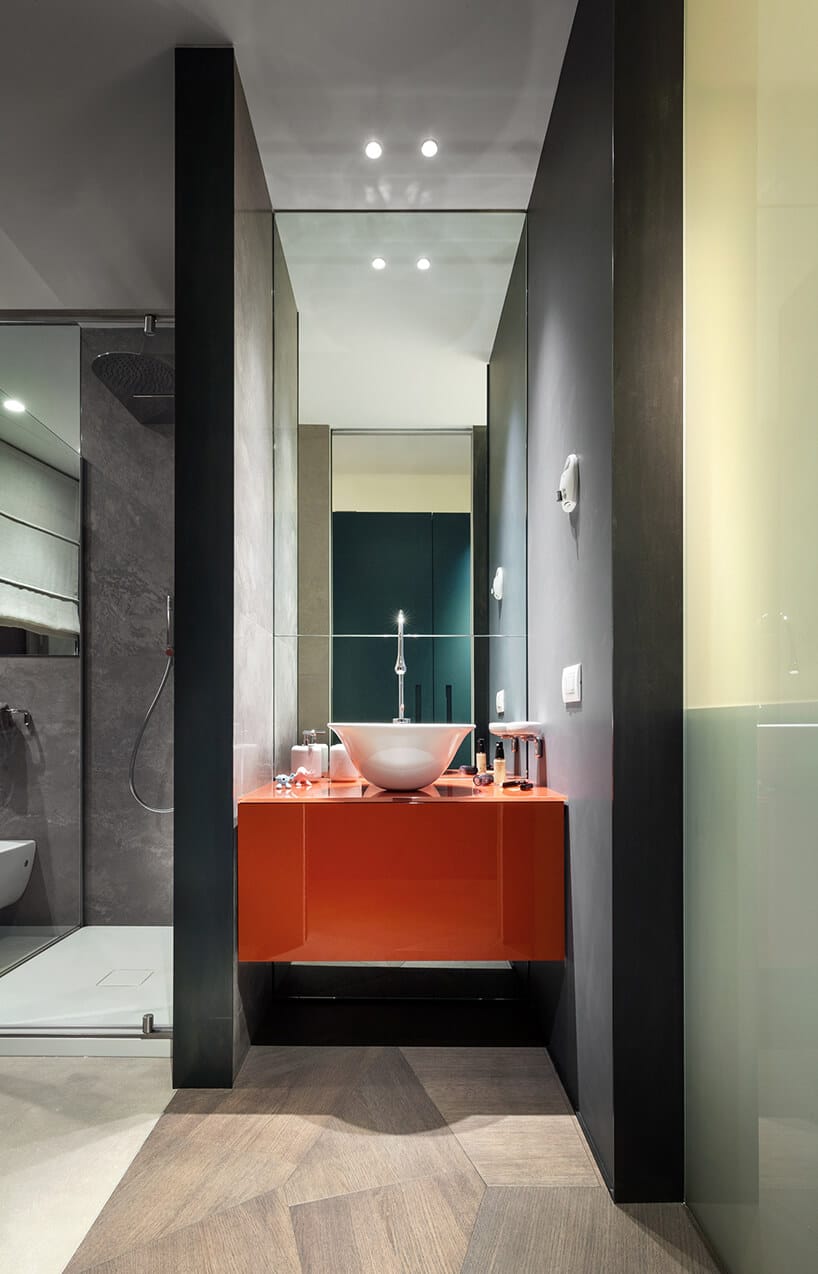 elegancki penthouse od Zaha Hadid łazienka z szarymi ścianami wolnostojąca umywalką na pomarańczowej szafce