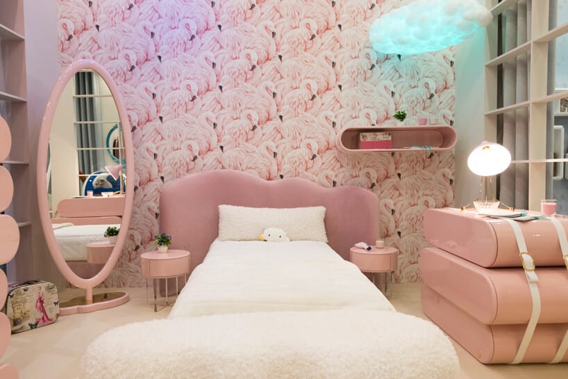 białe łóżko w różowym pokoju dziecięcym z wysokim lustrem i różową komodą