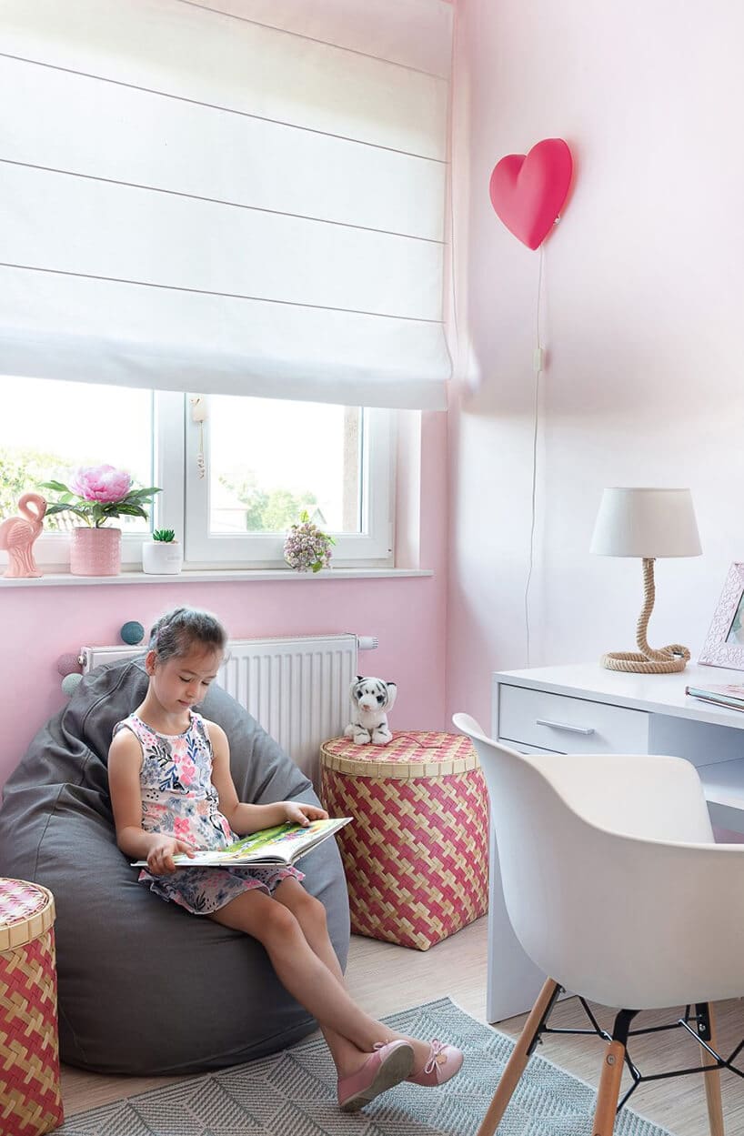 pudrowo różowe wnętrze pokoju dla dziecka ucznia z ładnym lekko niebieskim biureczkiem 