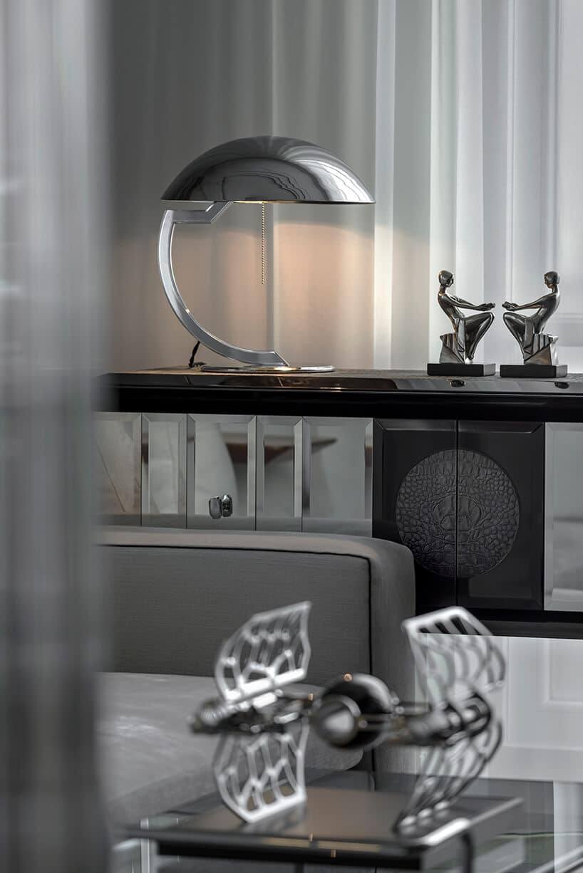 elegancka srebrna lampa na nowoczesnej komodzie ze szklanym i drewnianym wykończeniem