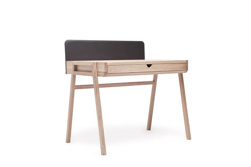 wyjątkowe małe drewniane biurko na drewnianych nogach z wmontowaną szufladą z czarną ścianką z tyłu