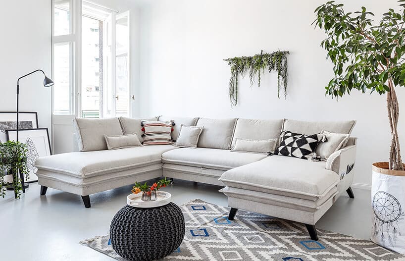 nowoczesna biała sofa narożna w białym wnętrzu