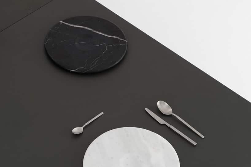 zestaw Moon Plate od Tre Product czarny i biały talerz z 3 sztućcami na czarnym blacie