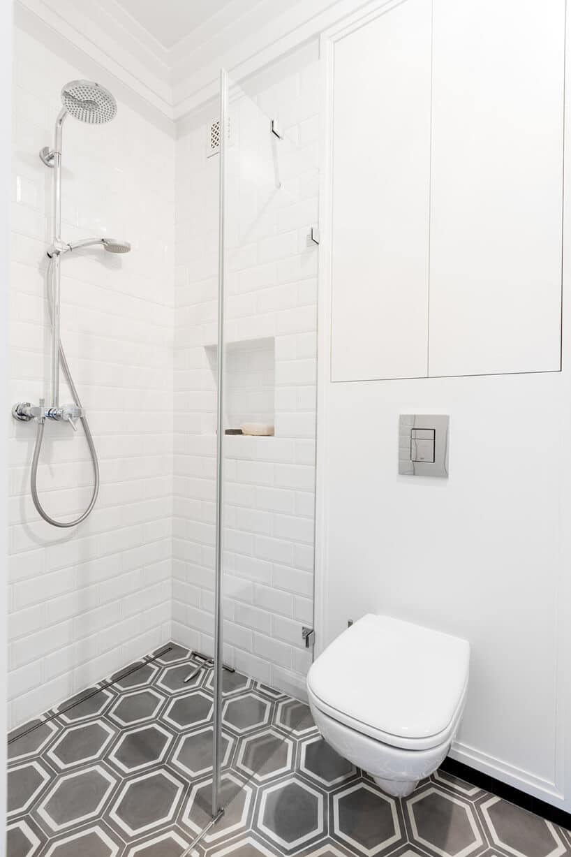 biała łazienka z dużym prysznicem i czarną podłogą