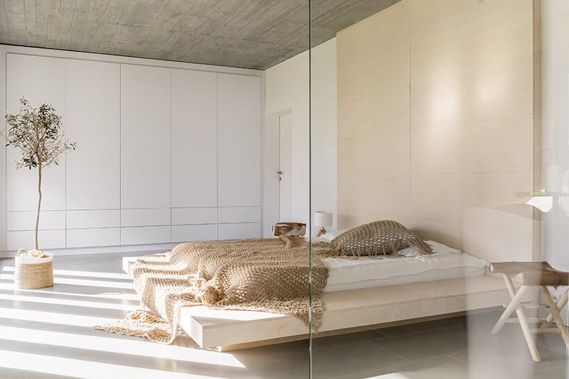 minimalistyczna sypialnia z lewitującym łóżkiem w sypialni z beżem oraz bielą oraz szkłem