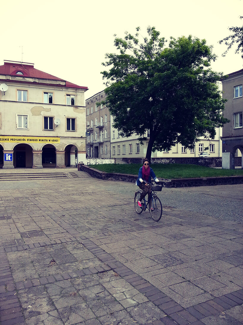 kobieta jadąca na rowerze po dużym placu