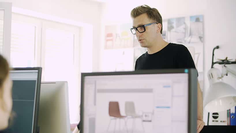 Tomek Rygalik w tle podczas projektowania na komputerach