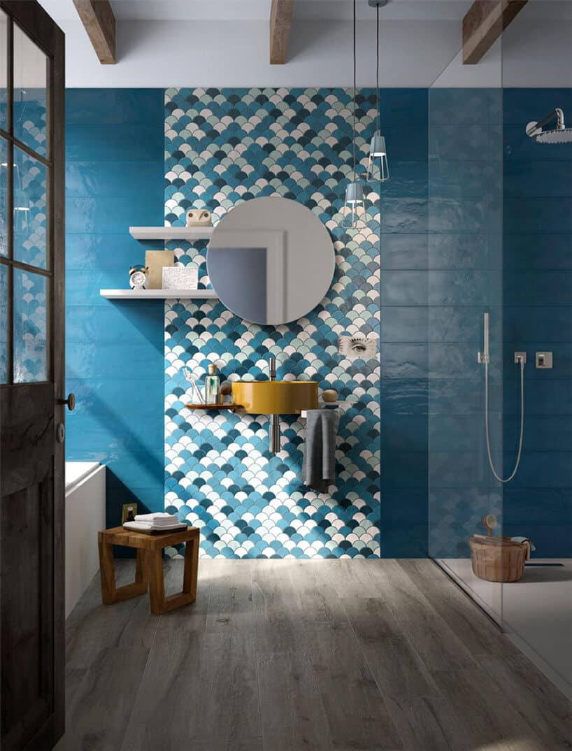 wyjątkowa niebieska łazienka z owalnymi płytkami za lustrem i żółtą umywalką