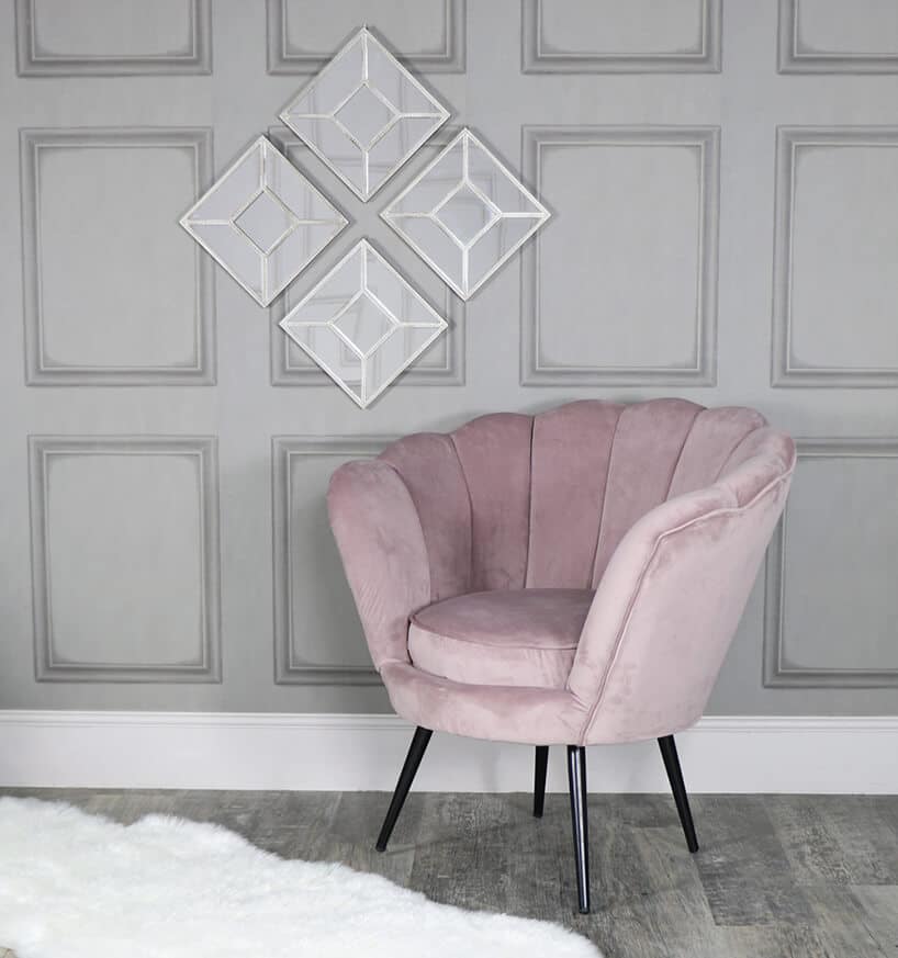 fioletowy fotel na tle szarej ściany z kwadratową dekoracją