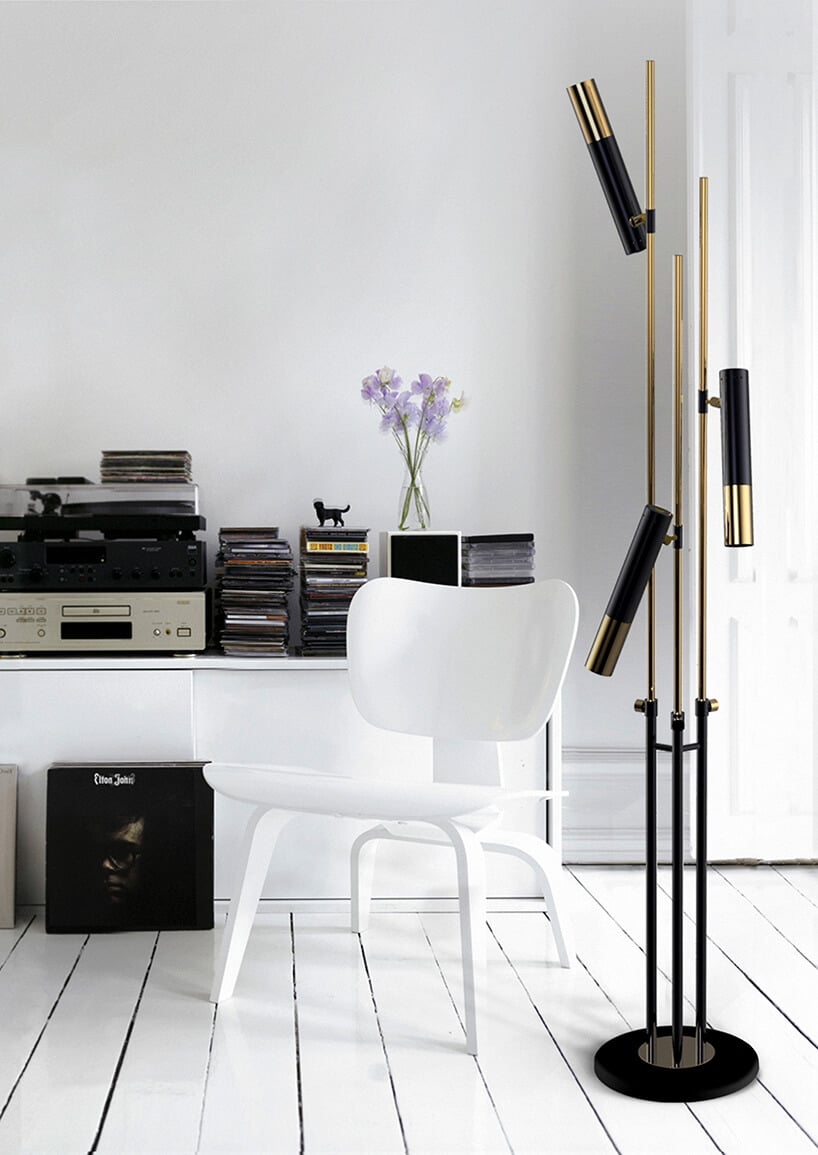białe wnętrze salonu z wyjątkową czarną stojąca lampą ze złotymi elementami
