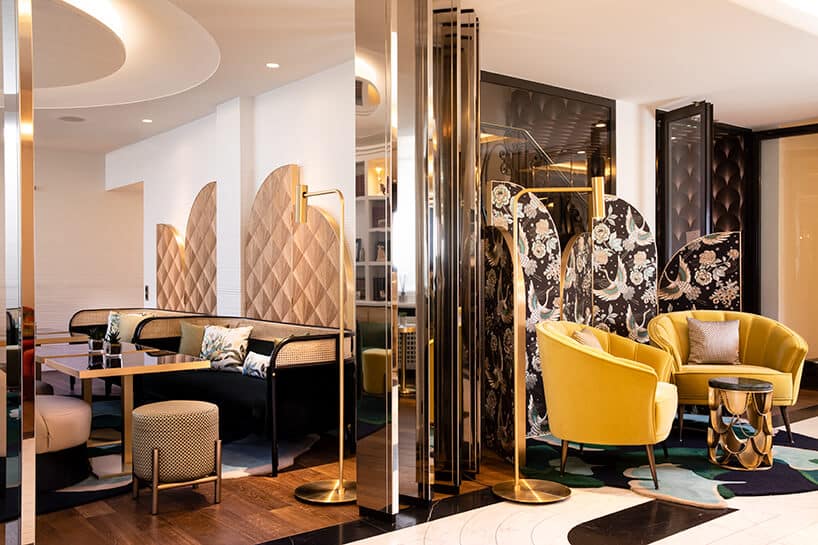 wnętrze w stylu glamour ze złotymi dodatkami i żółtymi fotelami przed małym złotym stolikiem