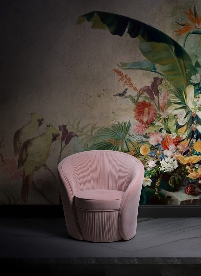 różowy fotel na tle ściany z roślinym motywem