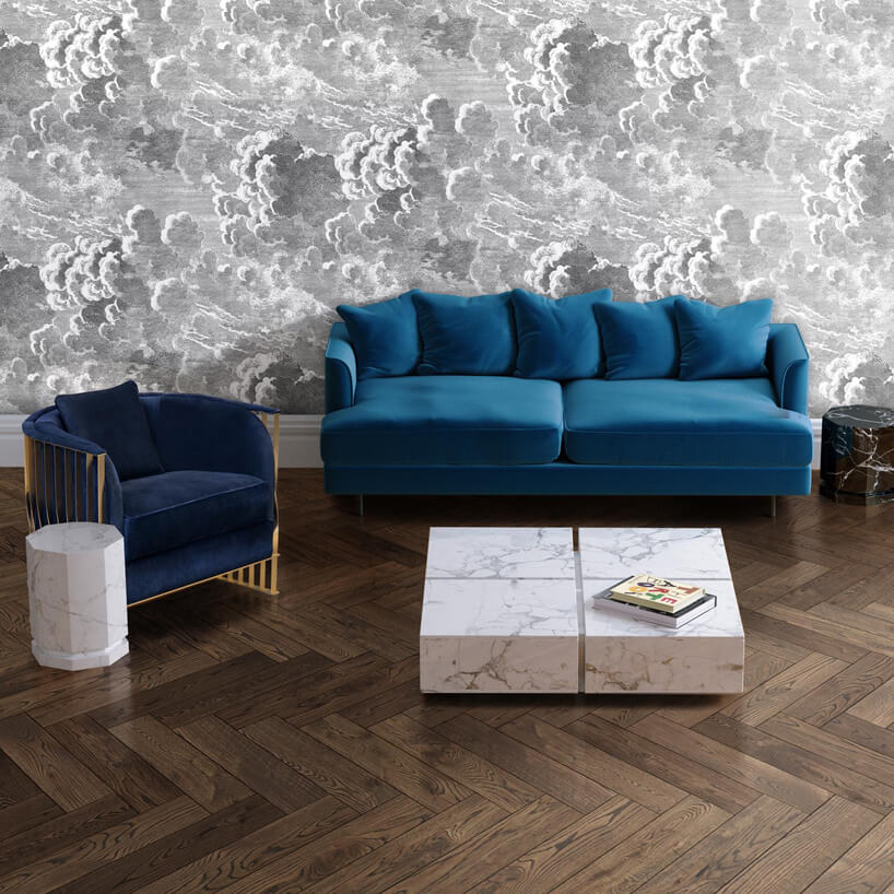 ciemna drewniana podłoga z niebieską sofą i fotelem przy niskim toliku 