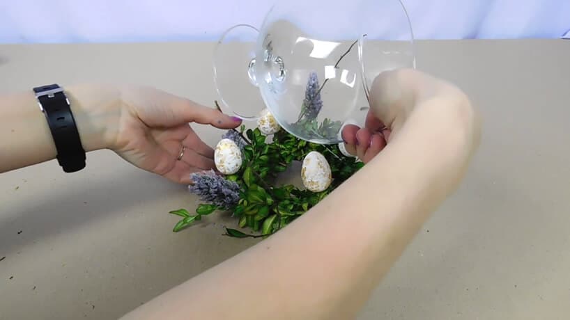 ustawianie szklanego wazonu na stroiku z bukszpanu